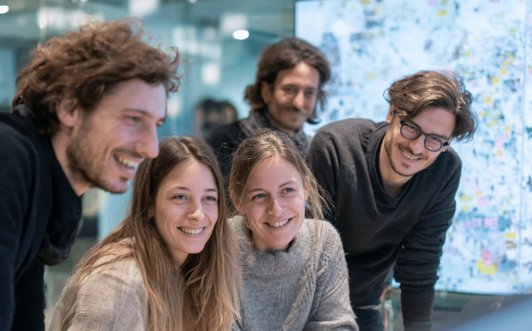 swiss ntb five smiling people designing together in front of a 0ceff2e3 fb85 49e9 bc71 4d05cecdbffa